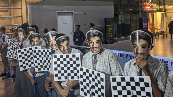 钦奈机场，戴着古克什面具的学生们等待迎接这位 17 岁的少年